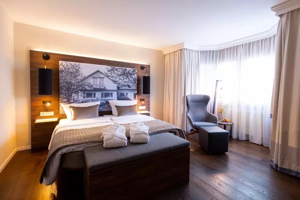 EIn Premiumzimmer im Landhotel am Rothenberg mit großem Bett und einem Bild hinter dem Bett