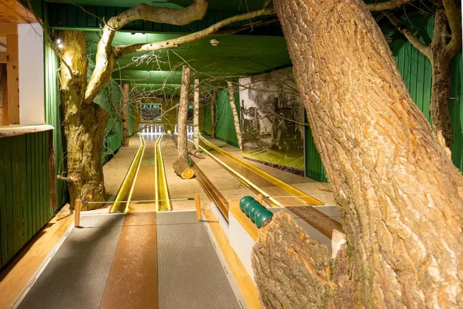 Blick auf eine Kegelbahn, die mit Baumstämmen dekoriert ist